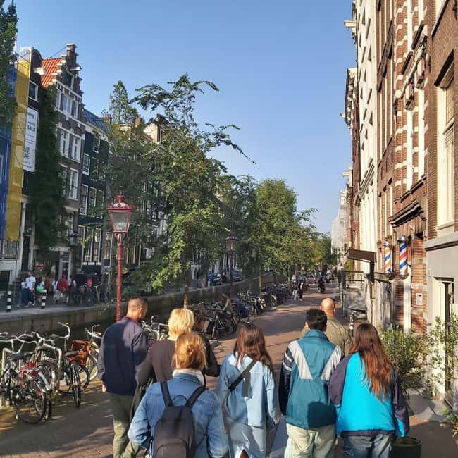 Amsterdam: Spanish Tour Unmasking the Redlight District - Walking the Red Light District Canal Network: Old Streets, New Meanings