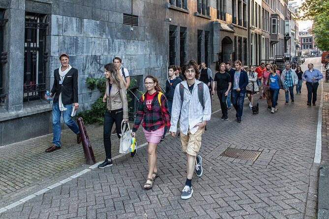 Amsterdam Walking Tour with a local comedian as guide - Stop 2: Dam Square and Damstraat plus the coat of arms twist